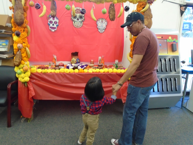 father and child view a Day of the Dead Altar