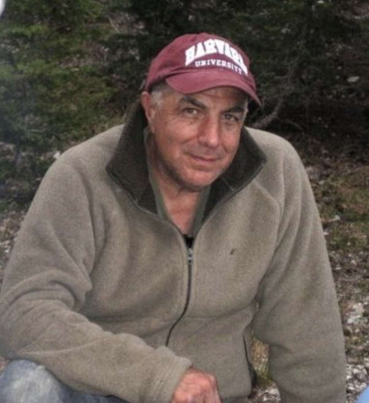 Photo of author in casual clothing and baseball cap with small smile