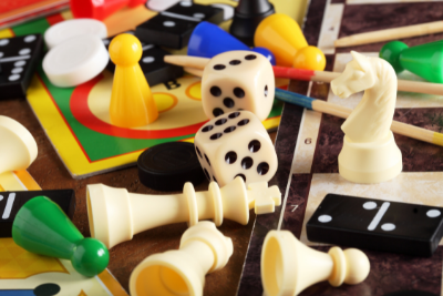 An image of jumbled up board game pieces in varied colors on an unidentifiable gameboard.