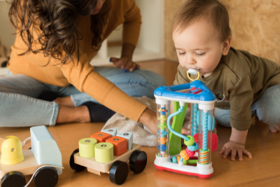 Photo of parent playing with baby on the floor.