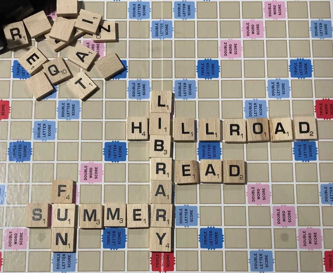 scrabble game tiles spell out words like Hill Road, Library, Read, Summer, Fun