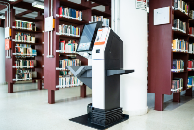 Library Service - Self-Check - Self-checkout station at the end of a library book shelf stack