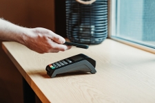 Person paying by phone on card scanner.