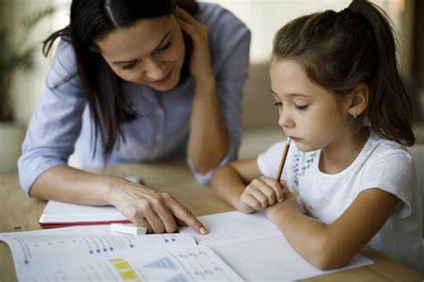 Teacher helps young student with homework.