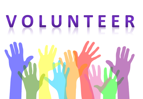 The word volunteer with colorful raised hands.