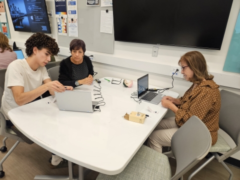 3 people using computers and talking