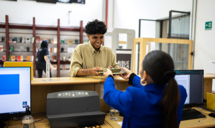 person helping someone at a circulation desk