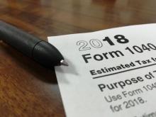 Photograph of 1040 tax form and stapler on table