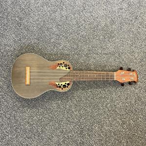 close up photo of a ukulele showing its 4 strings over the sound hole