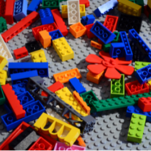 Multicolored and shaped Lego bricks spilled over a gray base plate.